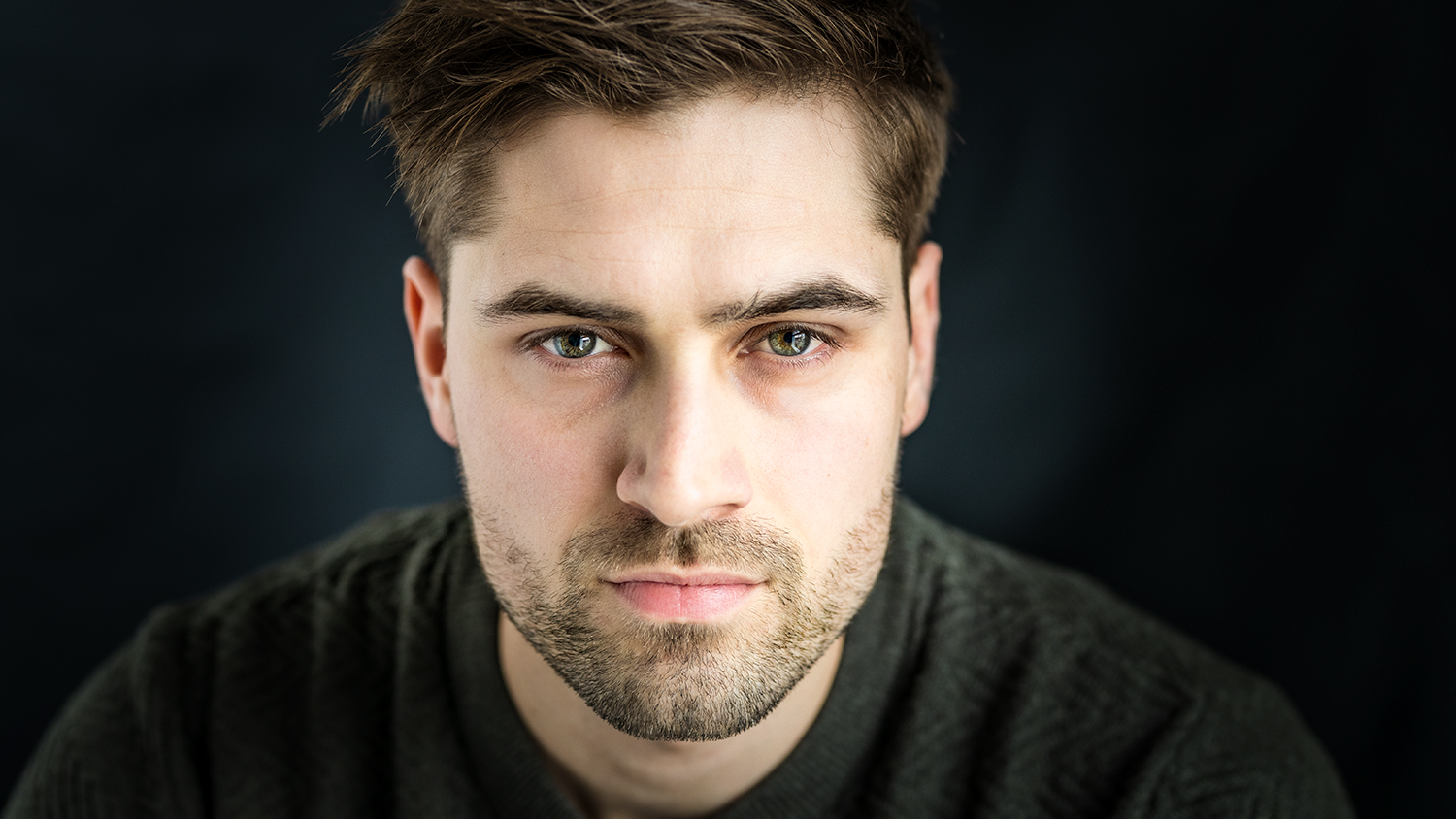 Headshot of man with stubble and green eyes